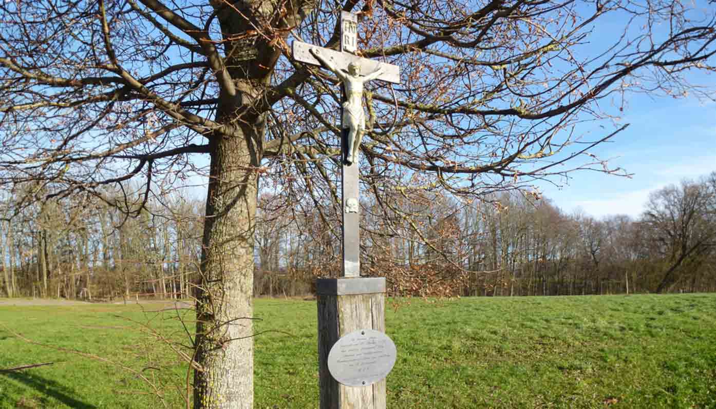 Ein Kreuz am Wegrand und seit letztem Jahr eine Gedenktafel an der Friedhofsmauer erinnern in Kay an Ferdinand Joly (1765-1823).